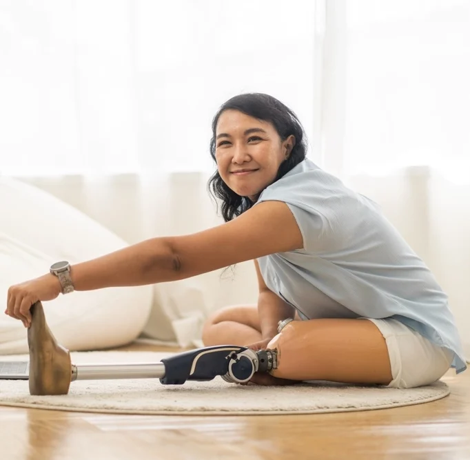 a women with prosthetic leg stretching in her home