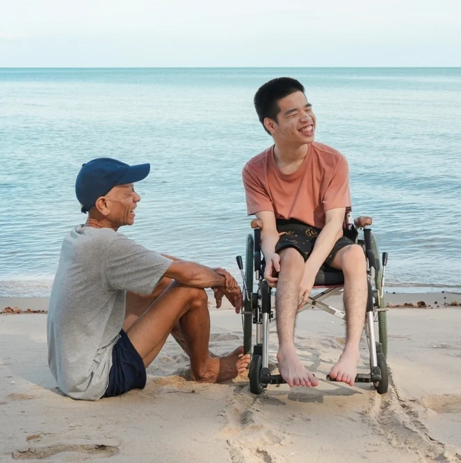 nurse with a disabled young boy by the beech